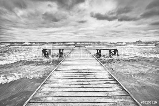 Bild på Old wooden jetty during storm on the sea Dramatic sky